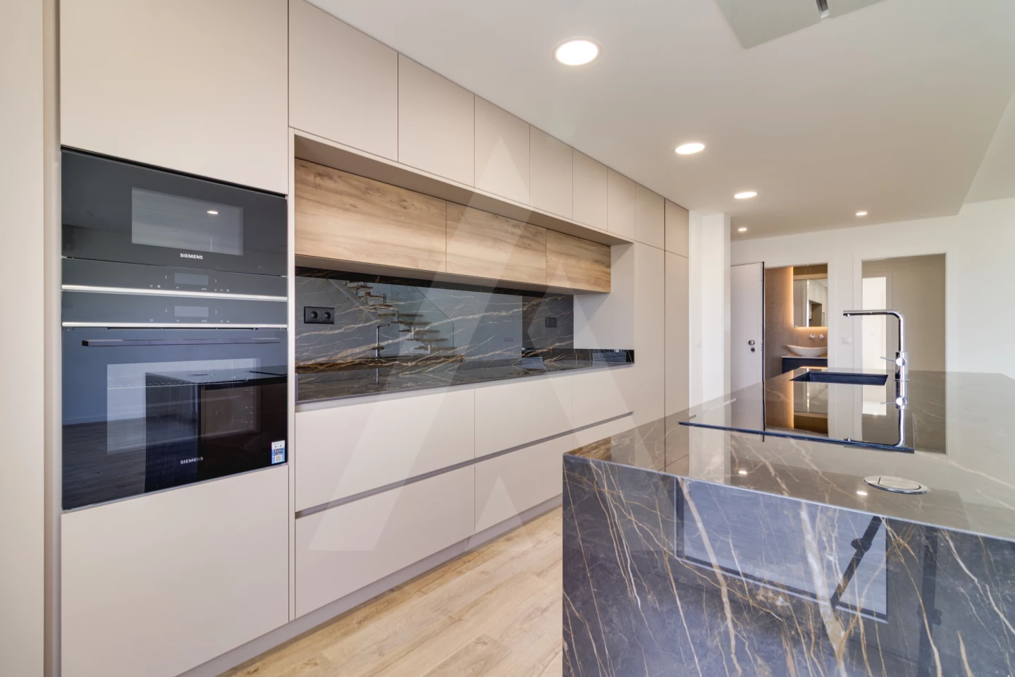 Cozinha equipada com eletrodomésticos Siemens e ilha em mármore
