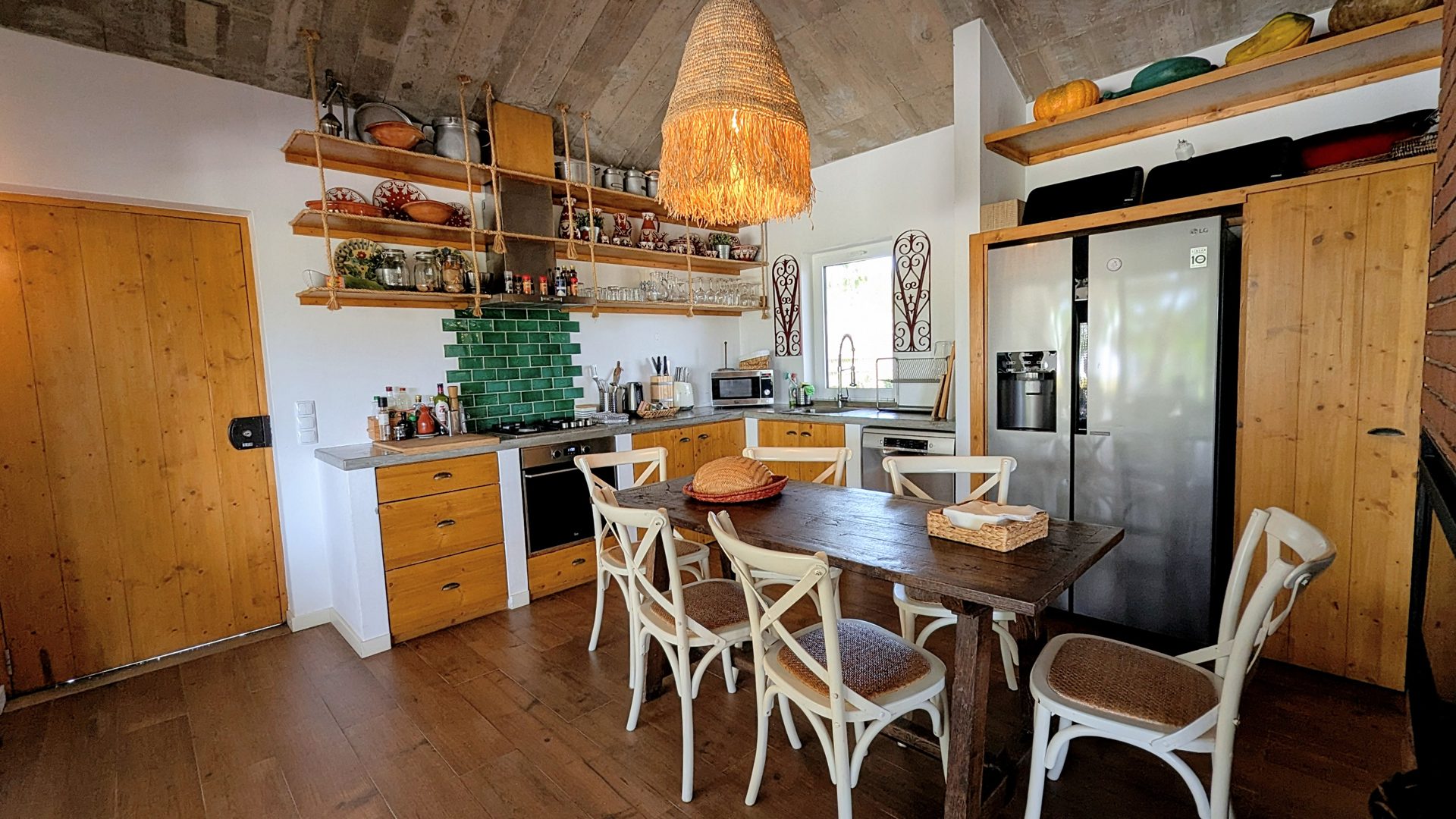 Cozinha em open space com ilha e mesa de refeições